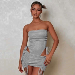 Detail of silver glittering fabric showing drawstring ruching and metallic texture on skirt