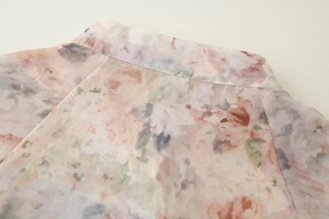 Détail macro des coutures sur l'encolure et l'épaule de la chemise à fleurs à manches longues
