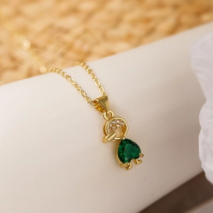 Detail of 18K gold necklace featuring a heart-shaped green zircon on a girl pendant