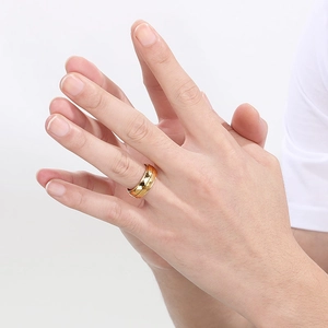 Macro detail of golden geometric rhombus patterned stainless steel ring on finger