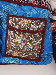 Detail view of quilted floral cotton jacket with ethnic patchwork patterns and pocket stitching