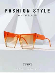 Detail view of large cat-eye orange gradient sunglasses with triangle metal rivets