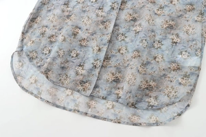 Détail d'une chemise en popeline à fleurs bleu clair montrant l'ourlet et le tissu doux