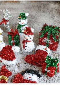 Flat lay of colorful glittery snowman, reindeer, and gift charms for Christmas decoration