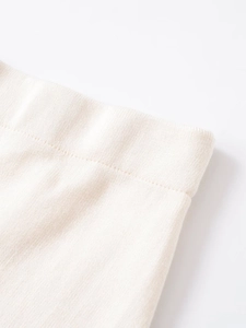 Dettaglio ravvicinato della vita elastica sulla gonna midi in maglia pizzo bianco crema