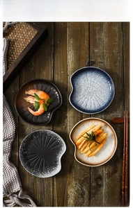 Close-up of four ceramic dipping dishes with retro glaze and irregular bean-shaped edges