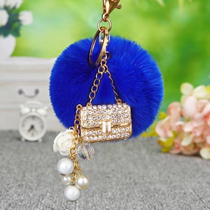 Detail of royal blue faux fur keychain with rhinestone handbag charm and pearls