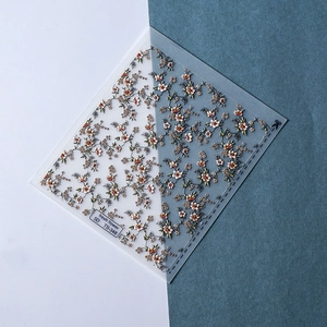 Detail showing 5D embossed floral nail stickers with white and yellow flower patterns