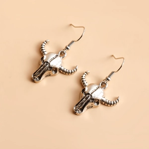 Gros plan sur les boucles d'oreilles tête de mort en argent au style punk vintage