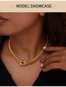 Close-up of golden double-layer snake chain necklace with a unique knot design on model