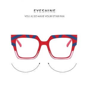 Close-up of square blue light glasses with red and blue stripes and gradient pink frame