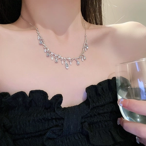 Metallic branch necklace with crystal waterdrop pendant worn on woman neck