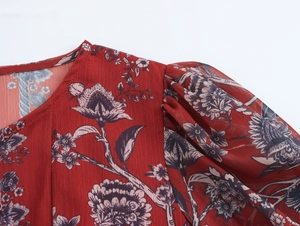 Detail view of the floral print chiffon top neckline and shoulder with red floral pattern