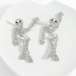 Close-up of silver skull skeleton earrings with white rhinestones and black stone eyes