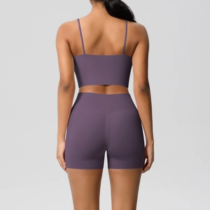Back view of a purple yoga set featuring a strappy sports bra and high-waisted gym shorts