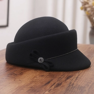 Detail of wool felt equestrian hat featuring a decorative bow and silver flower buckle
