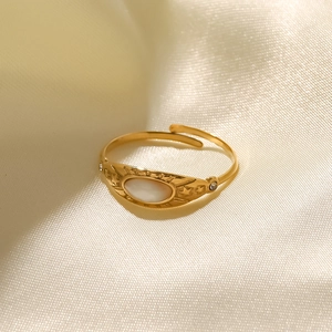 Close-up of golden vintage star ring with shell inlay on beige satin fabric