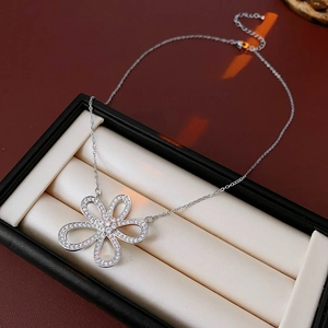 Vue détaillée du collier en argent avec pendentif fleur évidée et zircons dans un écrin