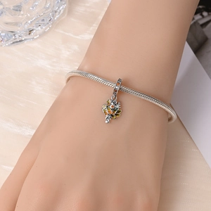Macro detail of silver snake chain bracelet with floral Faith pendant and colorful stones