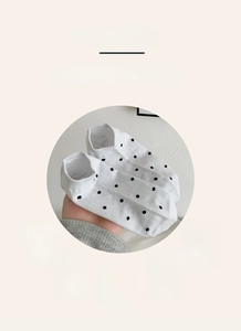Detailed view of white cotton invisible socks with black polka dots and breathable fabric