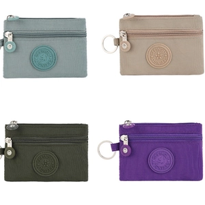 Detail of four colorful nylon mini wallets with double zippers and metal keyrings