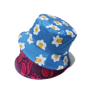 Detailansicht floraler Fischerhüte in Himmelblau und Magenta mit Seidenglanz