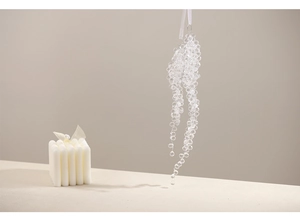Close-up of clear acrylic snowflake beaded ornament hanging in minimalist home setting