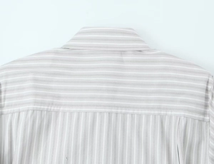 Détail de la chemise rayée grise et blanche avec épaulettes et coutures de précision