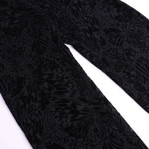 Gros plan sur le tissu dévoré en velours noir avec des motifs de papillons détaillés