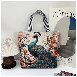 Detail showing 3D butterfly embroidery and peacock floral patterns on a canvas tote bag