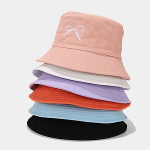 Detail showing variety of colorful canvas bucket hats with white bow embroidery