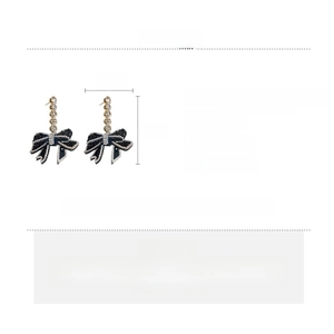 Detail view of bow earrings with black fabric, sparkling rhinestones and zircon crystals