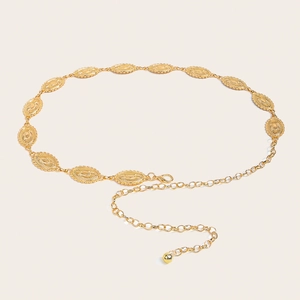 Macro view of gold metal waist chain with sunburst patterns and lobster clasp closure