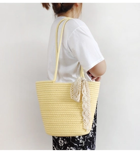 Detail of khaki woven cotton tote bag with white lace ribbon and textured pattern