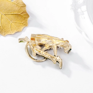 Vintage leopard brooch in gold alloy with green eyes on a ceramic plate display