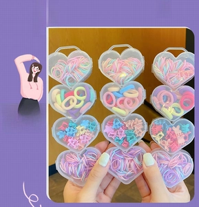 Detail of 12 heart boxes filled with colorful hair ties and mini flower hair clips