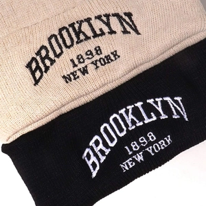 Beige and black Brooklyn embroidery knit beanies with ribbed texture for winter warmth