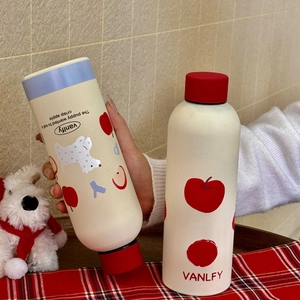 Detail of matte cream stainless steel bottle with apple motif on red checkered cloth