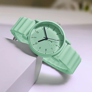 Detail of mint green quartz watch with wavy silicone strap on geometric prop