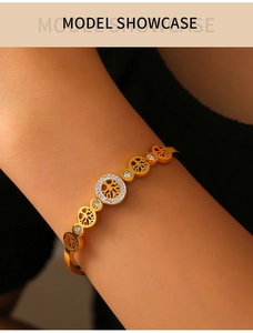Detailed view of gold tree of life bracelet with white zircon inlay on model's wrist
