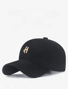 Close-up of golden H letter embroidery on high-density black cotton baseball cap