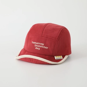 Detail of red baby soft brim hat with white embroidery and beige edge piping