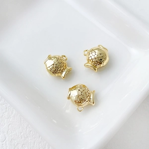 Detailed view of three 14k gold plated fish pendants for DIY jewelry making