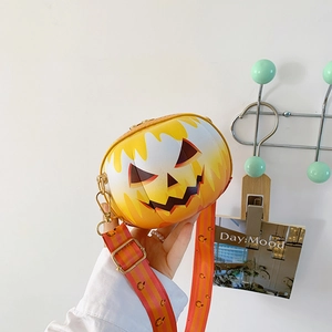 Detail of creative pumpkin-shaped crossbody bag with jack-o-lantern face and wide strap