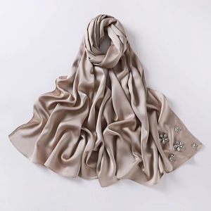Detail of champagne gold bubble chiffon hijab featuring handcrafted rhinestone floral accents