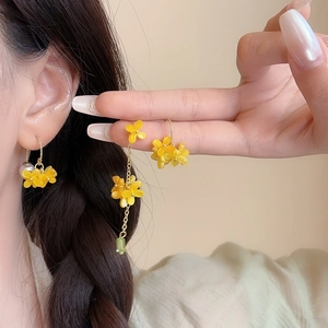 Elegant osmanthus flower earrings with pearls and green beads on a female model