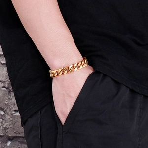 Gros plan d'un bracelet gourmette doré porté au poignet avec un éclairage naturel