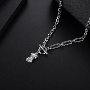 Silver bear pendant necklace with toggle clasp on a dark textured background