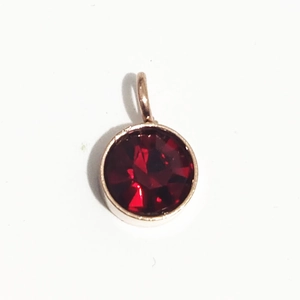 Vue détaillée d'un pendentif pierre de naissance rouge de 6mm avec monture dorée polie