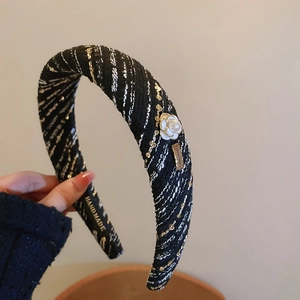 Detail of tweed headband featuring white pearl camellia flower and handmade metal charm